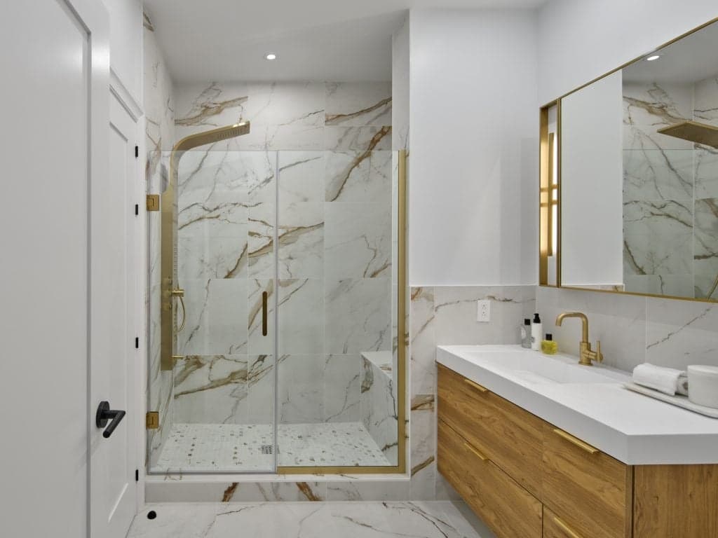 Marble-tiled bathroom with glass shower at 1001 Residences