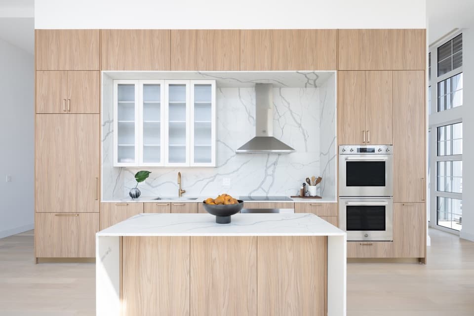 Unit kitchen with island and marble backsplash at Piazza Alta